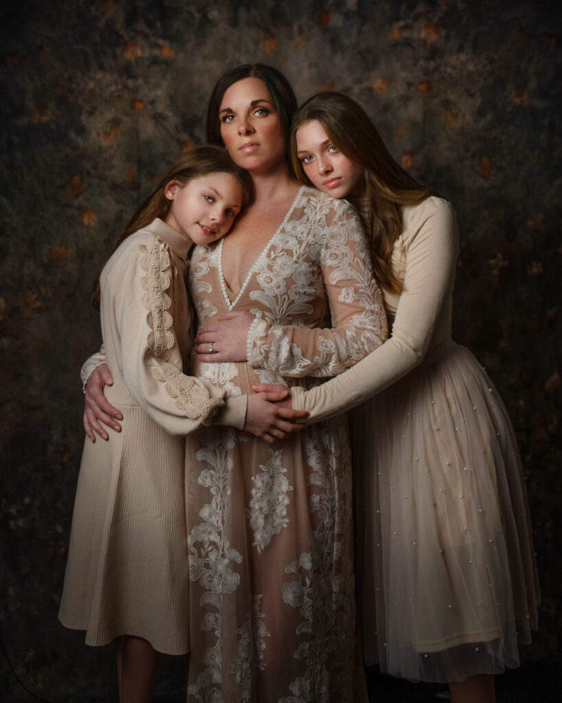 Capture the expecting mother with her loving daughters